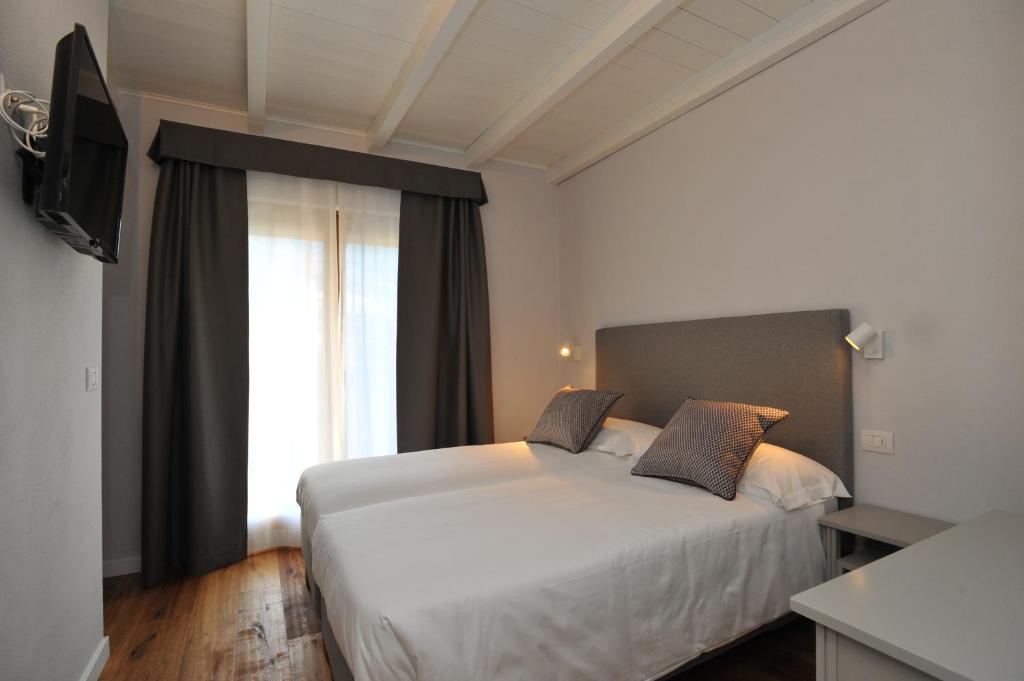 Mūsdienīgs viesnīcas numurs ar divām gultām, televizoru un dabiskiem gaismas avotiem. Interjers ir vienkāršs un elegants, ar koka grīdām un pelēku krāsu toņiem.