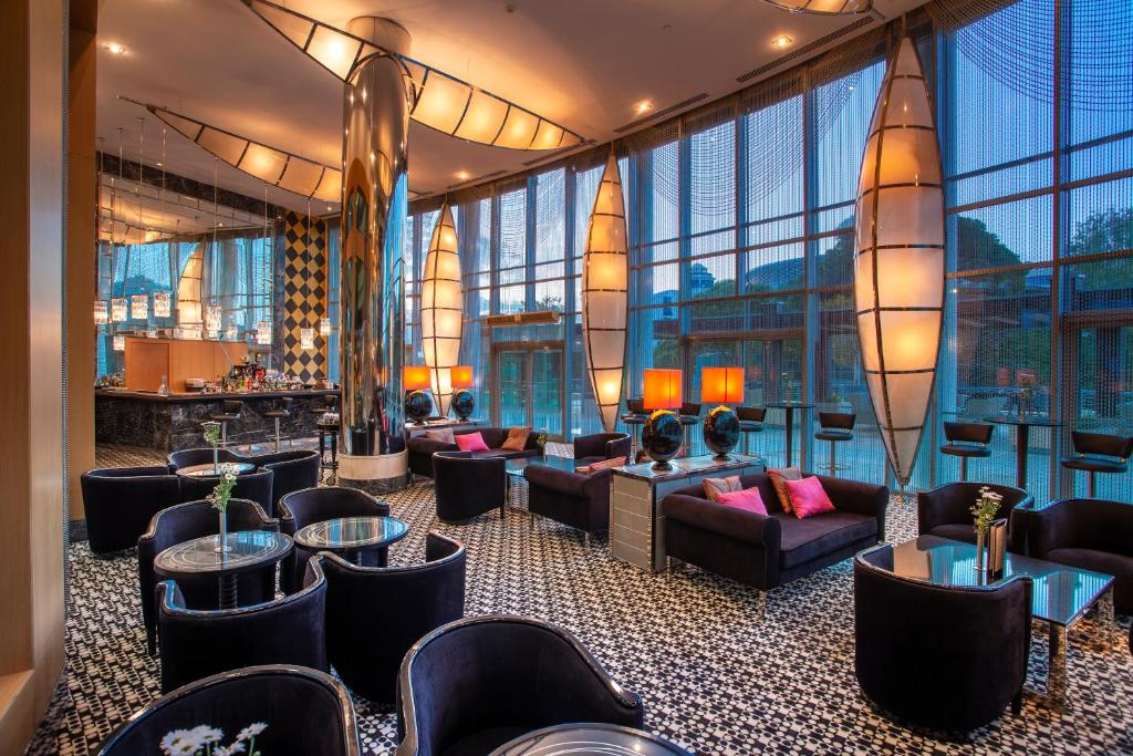 Mūsdienīgs un stilīgs viesnīcas bārs ar plašiem logiem, elegantiem dīvāniem un modernām gaismām, radot patīkamu atmosfēru. Ideāla vieta relaksācijai un sociālām tikšanās reizēm.