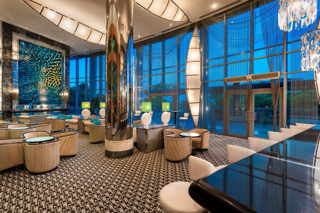 Moderns bārs ar elegantu interjeru, kurā ir izsmalcināti krēsli un galdi, kā arī lielas logu vitrīnas, kas nodrošina dabisko apgaismojumu un skatu uz ārpusi. Krāsainas mākslas gleznas un stilīgas apgaismojuma elementus piešķir vietai dzīvīgumu.