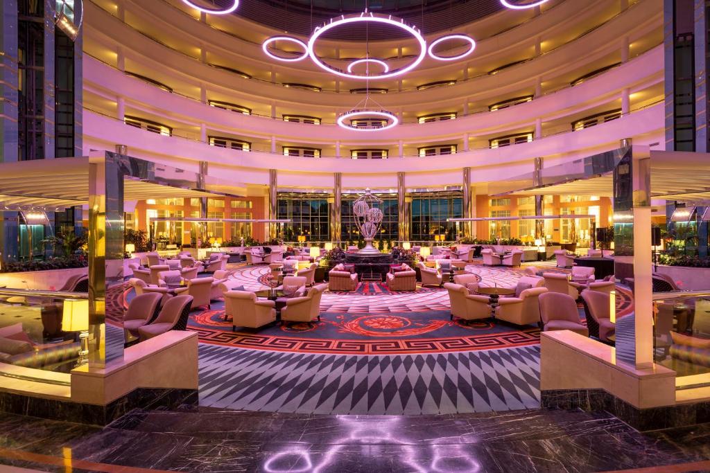 Luksusa viesnīcas vestibilis ar elegantu apgaismojumu un stilīgām mēbelēm, radot mājīgas un greznas atmosfēras sajūtu.