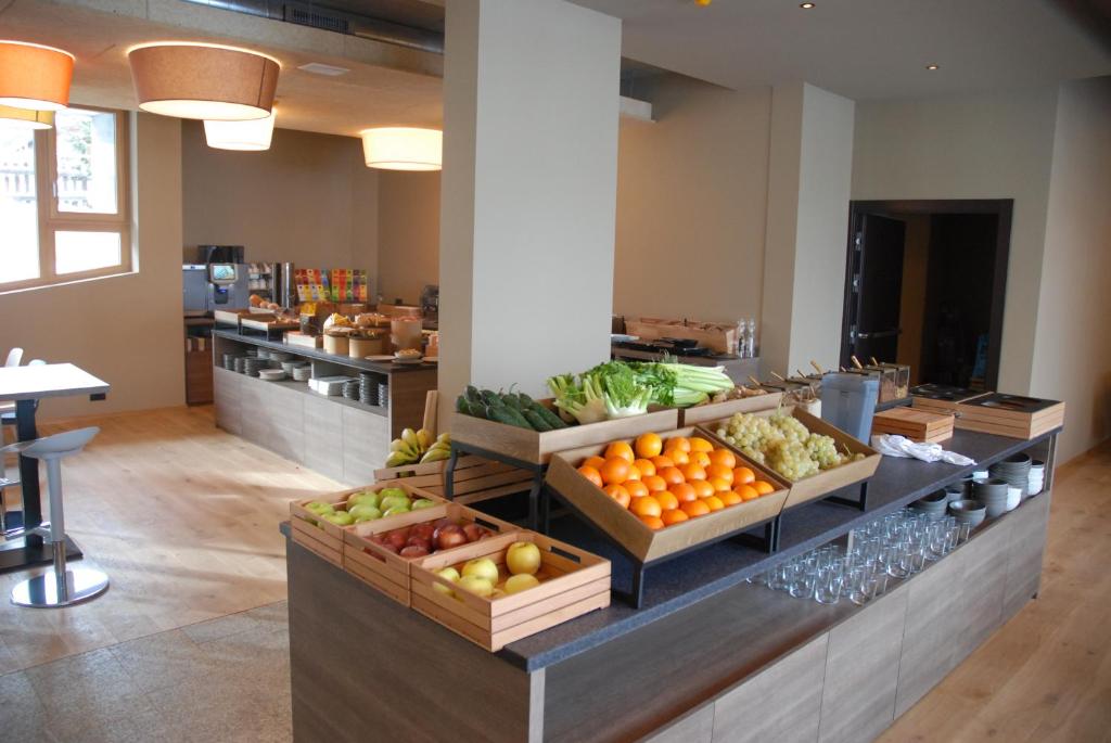 Moderns brokastu stūris ar svaigiem augļiem un dārzeņiem, kas sakārtoti eleganti koka grozos. Gaismas un telpas dizains rada patīkamu atmosfēru.