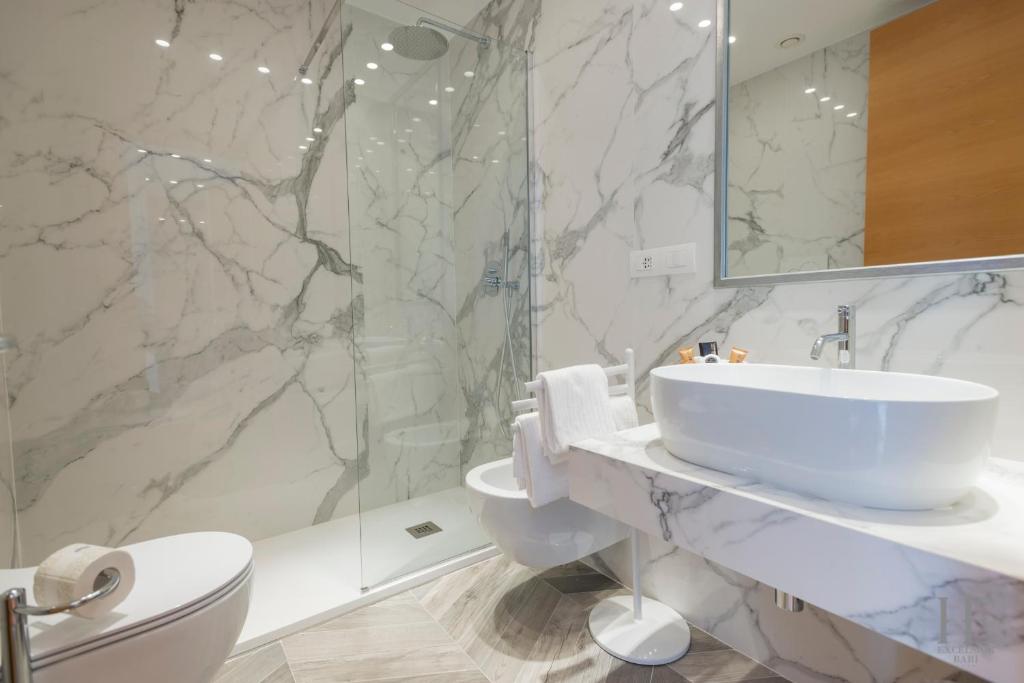 Moderns vannas istabas interjers ar marmora sienām, stikla dušu un elegantu izlietni. Stilīgs un funkcionāls dizains.