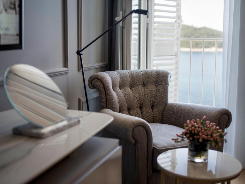 Mūsdienīga piekļuve ērta krēsla un nelielā galda ar ziediem, ar skatu uz jūru. Interjers ir elegants un gaišs, radot mājīgu atmosfēru.