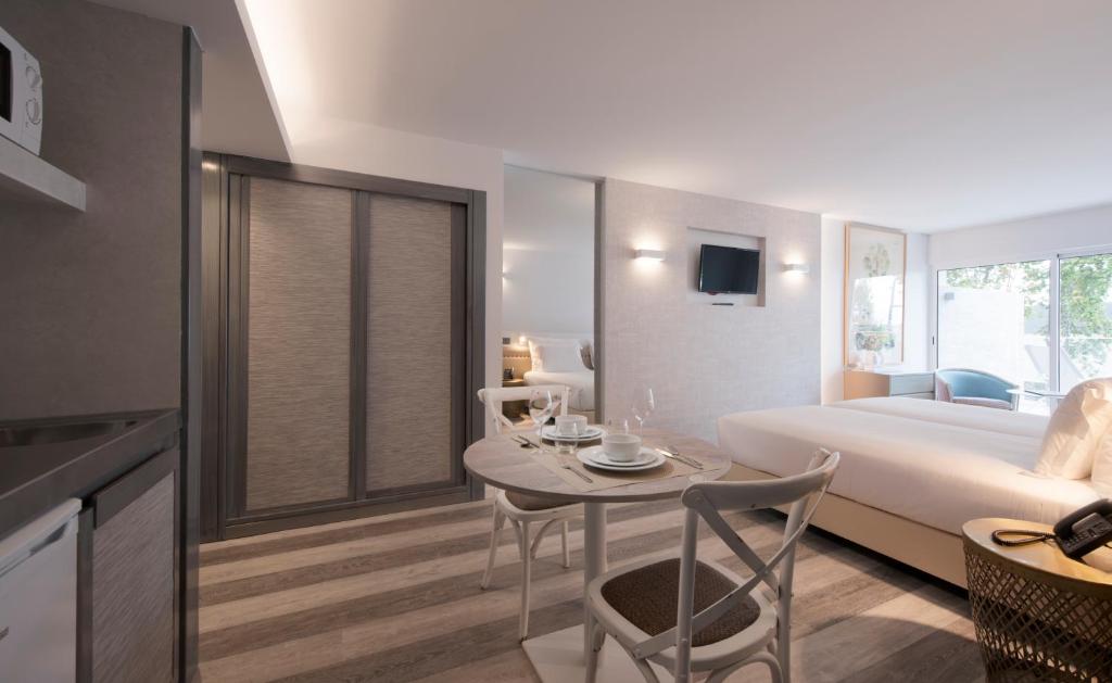 Mūsdienīgs viesnīcas numurs ar ērtu gultu, virtuvi un ēdamgaldu, kas izveidots gaišās krāsās. Telpa ir plaša un labi apgaismota, ar lieliem logiem, kas sniedz dabisko gaismu.