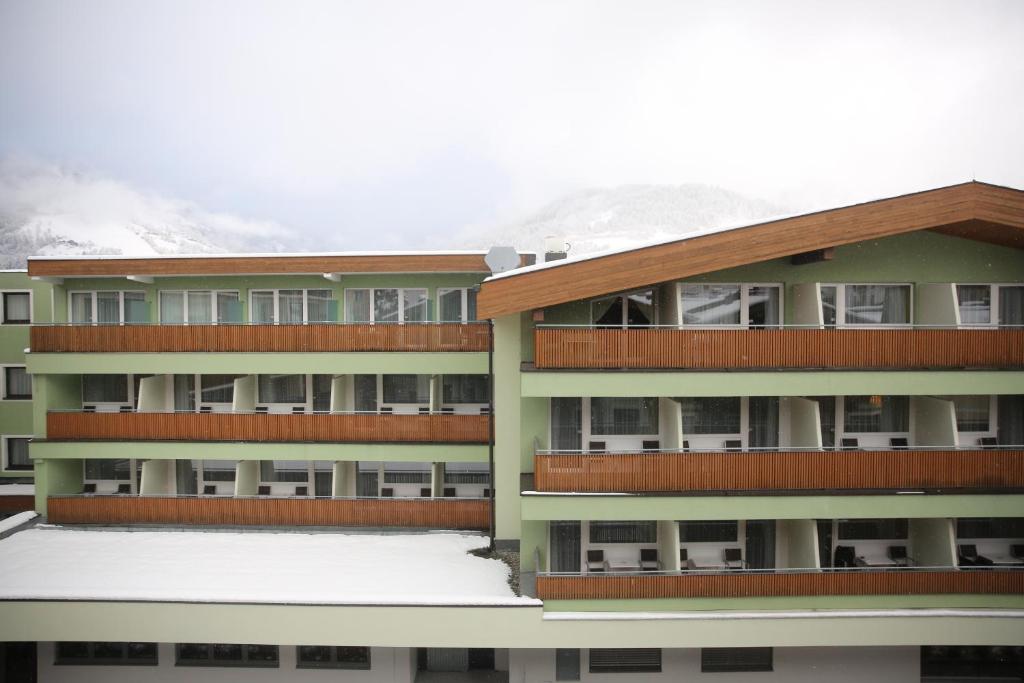 Moderns viesnīcas komplekss ar balkoniem, apņemts sniega seguma un kalnu ainavas. Svaiga gaisa un relaksācijas vieta ziemas sporta cienītājiem.