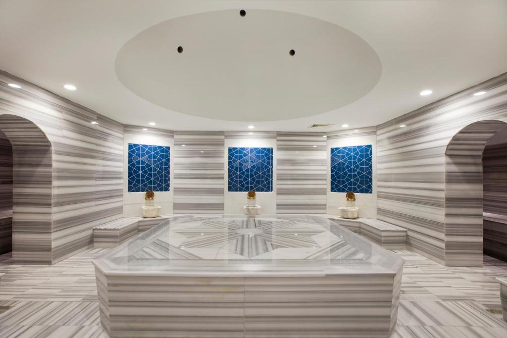 Mūsdienīgs tvaika pirts interjers ar elegantiem marmora elementiem, zilu stikla mozaīku un izsmalcinātām detaļām. Telpa rada relaksējošu un mierīgu atmosfēru.