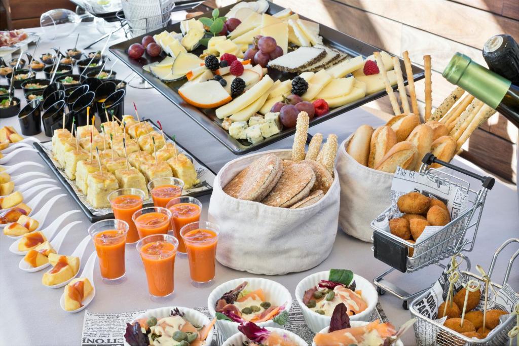 Skaists uzkodu galdiņš, kas ietver dažādas sieru šķēles, dārzeņu uzkodas, salātus un dzērienus, radot pievilcīgu un svinīgu atmosfēru.