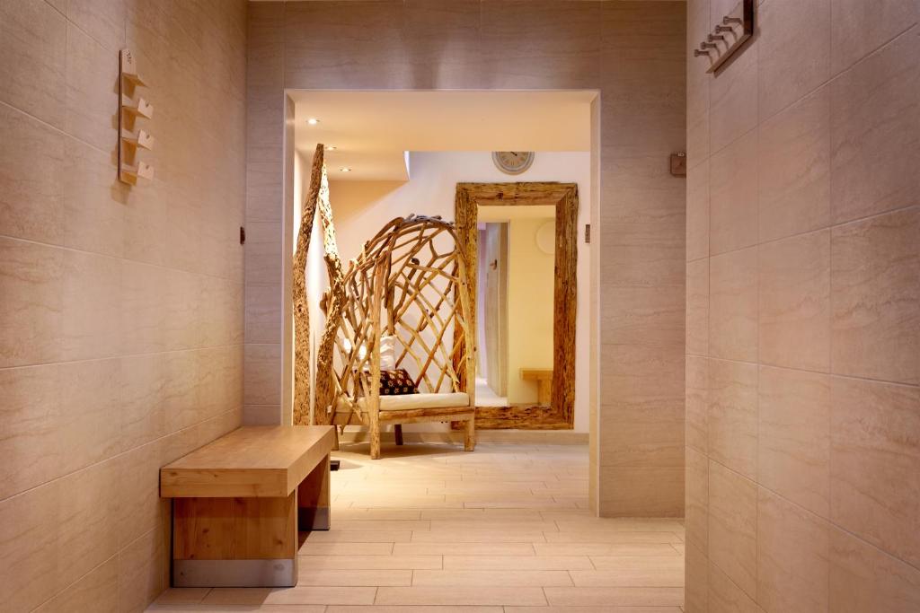 Mūsdienīga un gaiša ieeja ar koka soli un unikālu rotājumu, kas veidots no dabīgām materiālām. Telpa ir eleganta un aicinoša, ar siltiem toņiem un labu apgaismojumu.