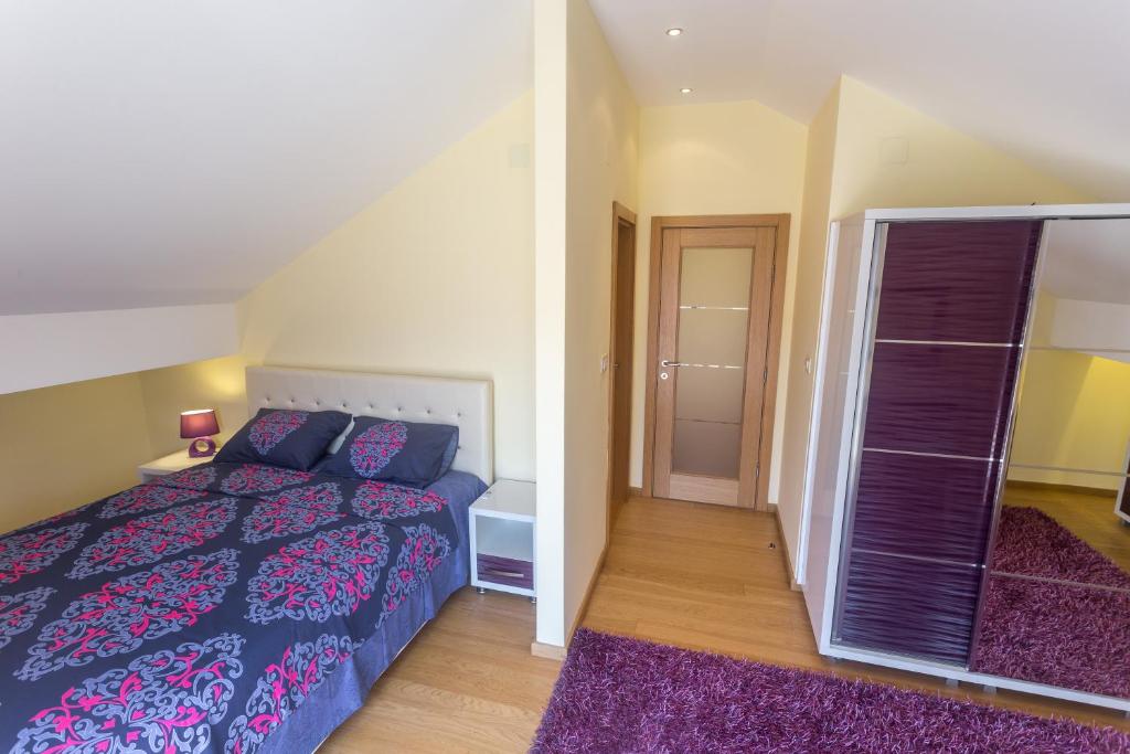 Moderns guļamistabas interjers ar stilīgu gultu, naktslampiņu un skapjiem. Telpa ir gaiša un mājīga, ar koka grīdu un mīksto paklāju.