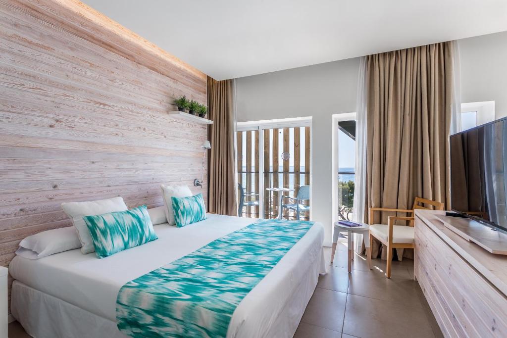 Mūsdienīgs viesnīcas numurs ar koka apdari, baltām gultām un krāsainām spilvendēkām, kas atrodas blakus balkonu ar skatu uz dabu. Numurā ir TV un koka mēbeles.