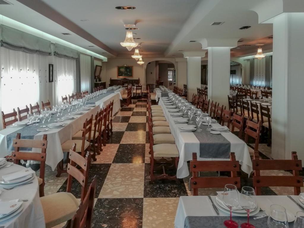 Restorāna iekšiene ar eleganti klātiem galdiem, kas gatavi viesu uzņemšanai. Gaismas un dekorācijas rada siltu un viesmīlīgu atmosfēru.