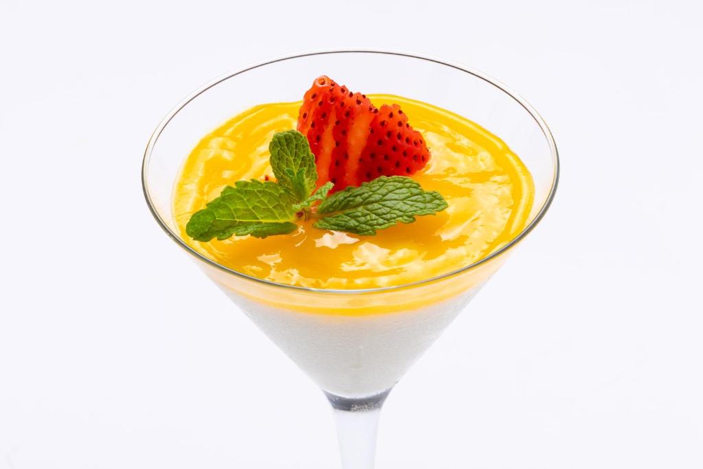 Krēmveida deserts, kas pasniegts martini glāzē, ar mango mērci, zemenēm un piparmētru dekorācijām. Ideāls našķis karstām dienām.