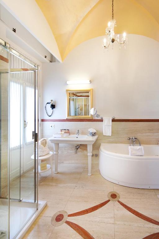 Mūsdienīgs vannas istabas interjers ar elegantu dušu, vannu un izsmalcinātu apgaismojumu, radot relaksējošu atmosfēru. Vannas istabā ir arī grezns spogulis un izsmalcinātas flīzes.