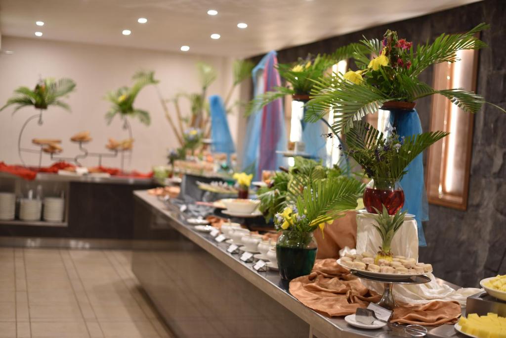 Svaigu augļu un ziedu dekorēta bufete ar dažādiem ēdieniem un elegantām servēšanas ierīcēm. Piemērota svinībām vai īpašiem pasākumiem.