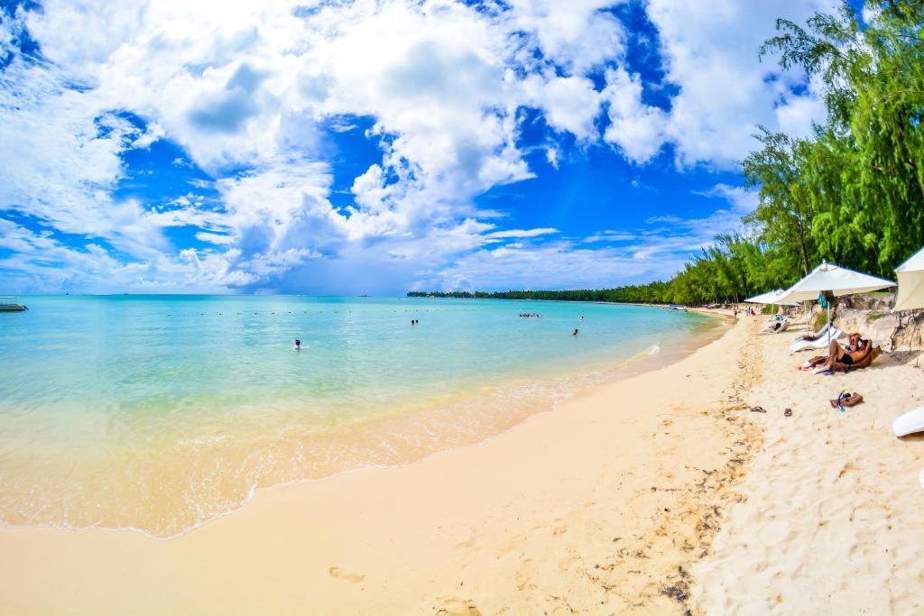Skaista pludmale ar smilšainu krastu un kristāldzidru ūdeni zem saulainā debesu skata. Ideāla vieta atpūtai un relaksācijai.
