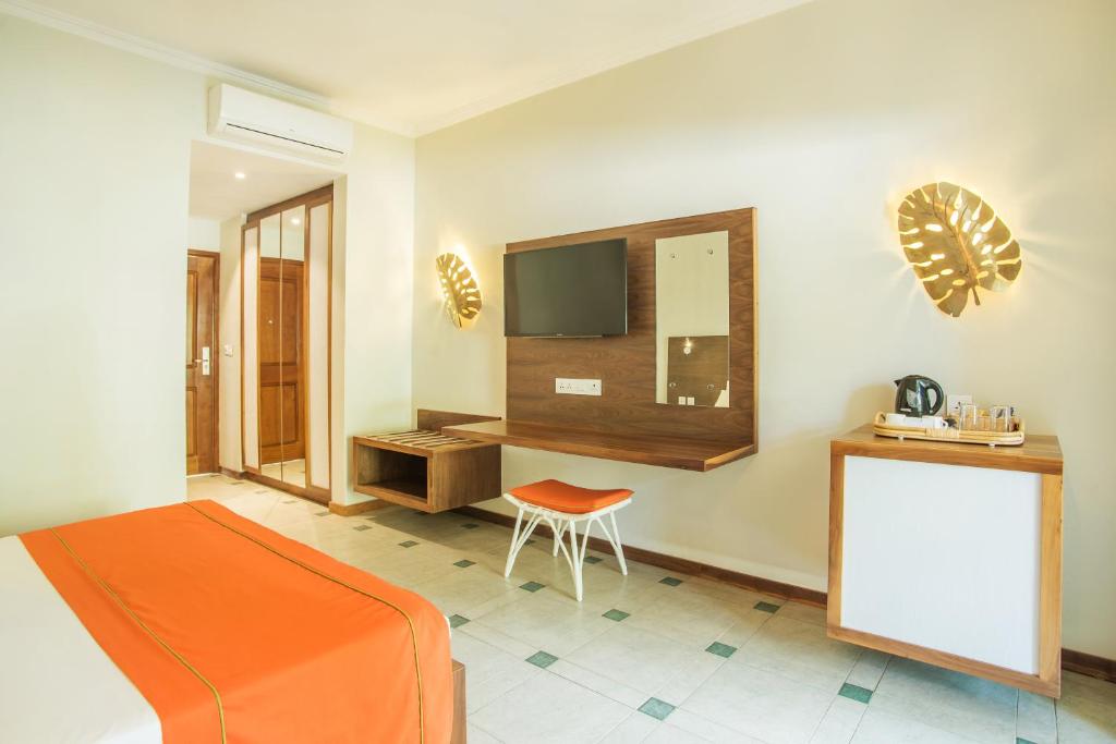 Mūsdienīgs viesnīcas numurs ar gaišām krāsām, koka mēbelēm un modernu televizoru, kas piedāvā komfortablu atmosfēru. Telpā ir ērta gulta, rakstāmgalds un viesu mīkstie krēsli.