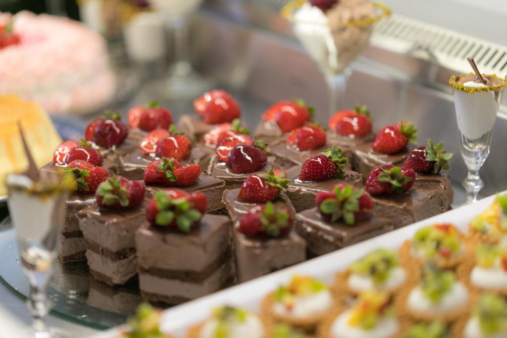 Šokolādes kūkas ar svaigām zemenēm uz galda, papildinātas ar garšīgām saldējuma porcijām un maziem desertiem. Ideāli piemērots svinībām un saldummīļiem.