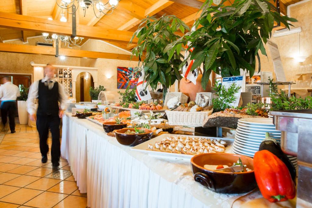 Brokastis bufete ar dažādiem ēdieniem un viesmīļiem restorānā. Svaigi augļi un dārzeņi papildina gardo izvēli.
