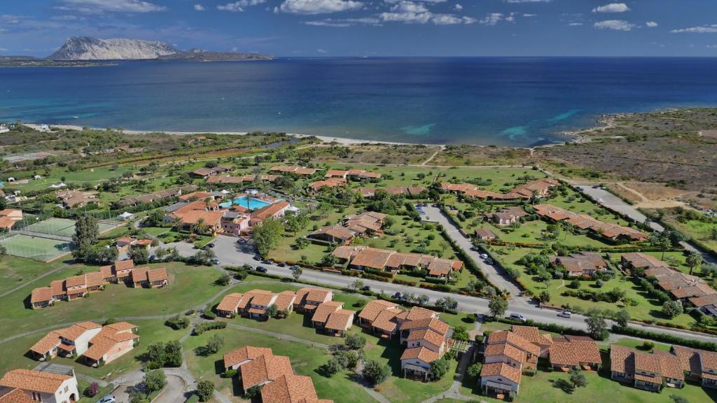 Ainava ar brīnišķīgu piekrasti, mājīgām villām un baseinu, kas atrodas netālu no jūras. Skats uz kalnu fona un zilo ūdeni rada mierīgu atmosfēru.