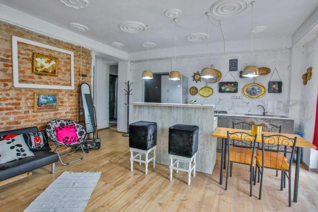 Mūsdienīga viesistaba ar sarkana ķieģeļa sienu, atpūtas zonu un virtuves daļu. Interjers ir apvienots ar mākslas darbiem un stilīgām mēbelēm, radot mājīgu atmosfēru.