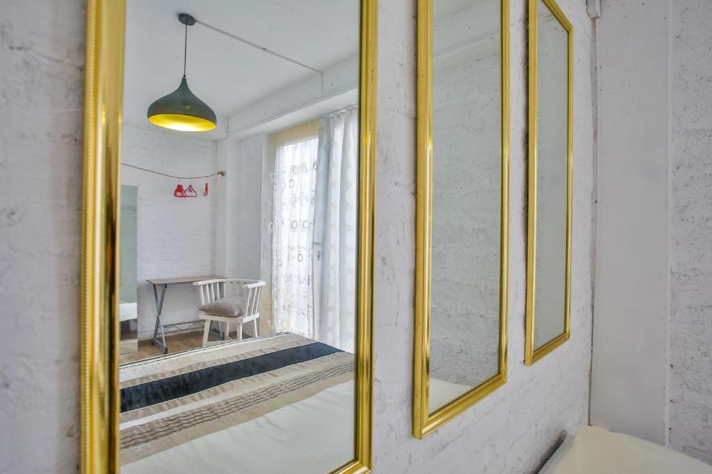 Interjers ar zeltītiem spoguļiem, kas atspoguļo mājīgu telpu ar baltiem sienām un gaismas avotu. Sākums ir ērta koka mēbele un gaisīga aizkars.