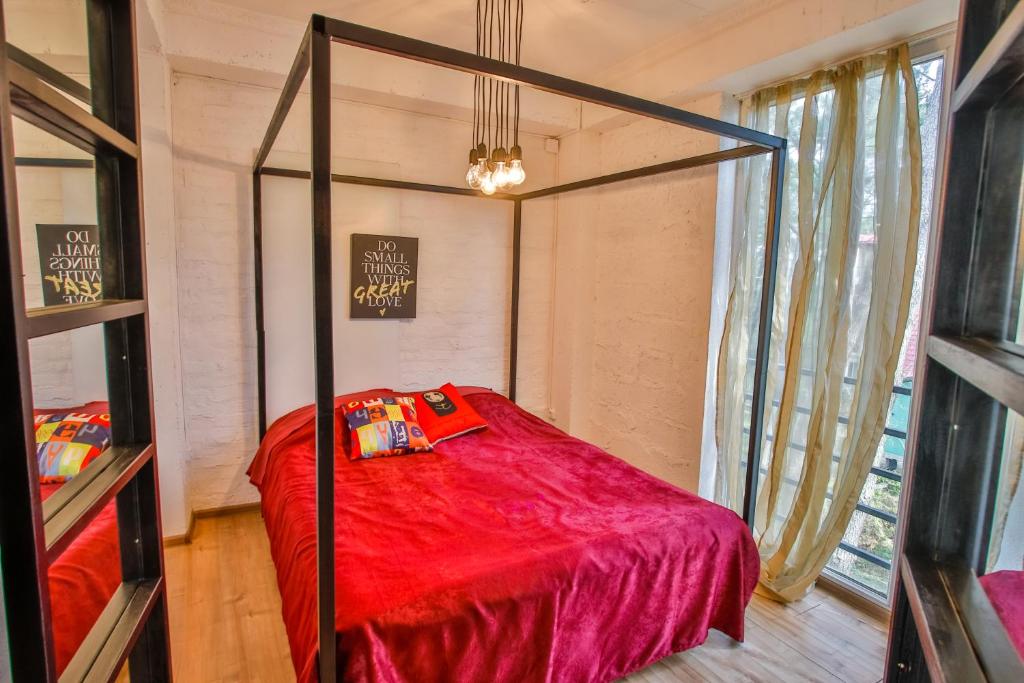 Guļamistaba ar četrām stūrēm, sarkanu gultu un spilveniem, kā arī dabiskiem apgaismojuma elementiem un logiem ar vieglām aizkariem. Ideāla vieta mierīgai atpūtai un komfortam.