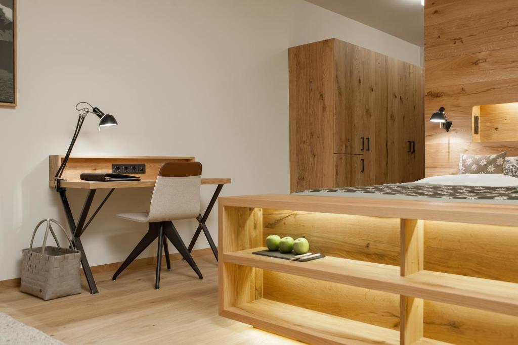 Mūsdienīgs guļamistabas interjers ar koka mēbelēm, darba galdu un ērtu krēslu. Gaismas elementu kombinācija rada siltu un viesmīlīgu atmosfēru.