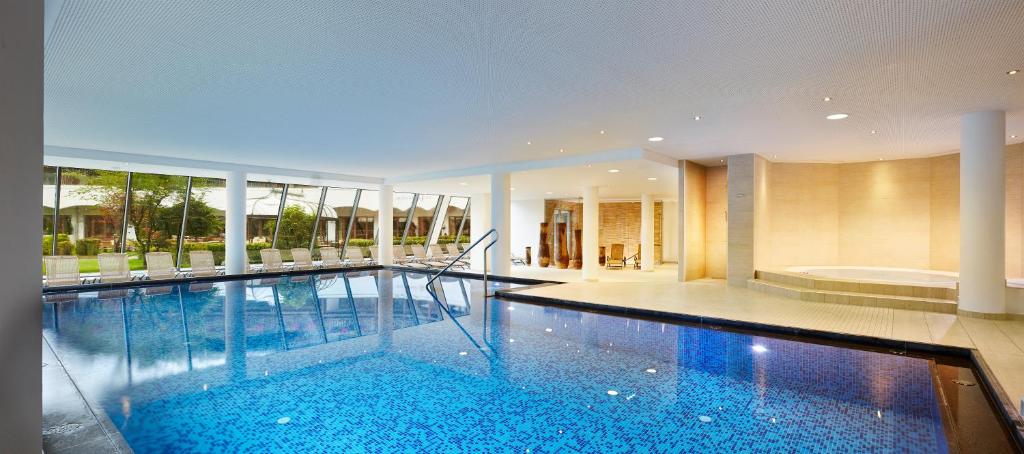 Mūsdienīgs iekštelpu peldbaseins ar stikla sienām, kas sniedz skatu uz dārzu, un relaksācijas zonas ar komfortablām atpūtas krēsliem. Ideāla vieta atpūtai un izklaidei.