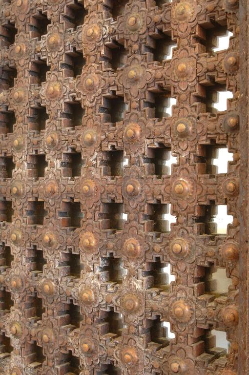 Koka režģis ar izsmalcinātu ziedu un ģeometrisku rakstu, radot interesantu tekstūru un dziļumu. Tā ir lieliska piemērs tradicionālajai amatniecībai.