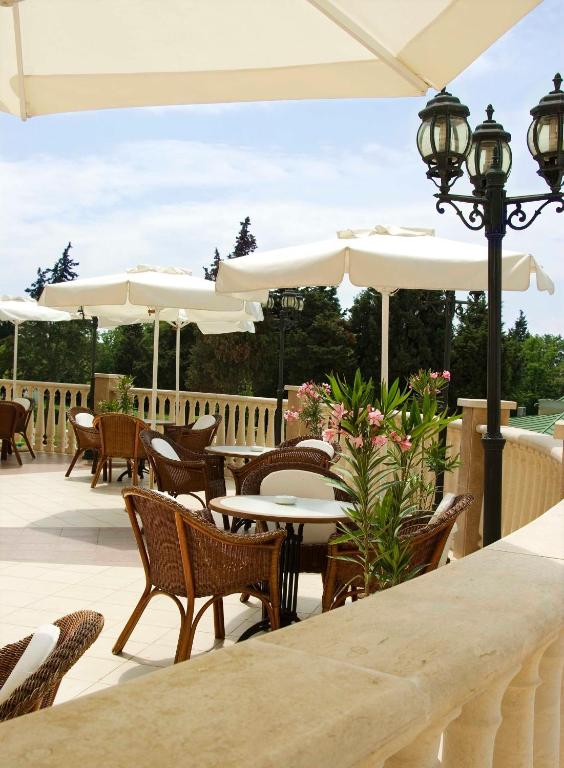 Terases skats ar vītņu krēsliem un galdiem, saulessargiem un dekoratīvām puķēm. Ideāla vieta relaksācijai un atpūtai svaigā gaisā.