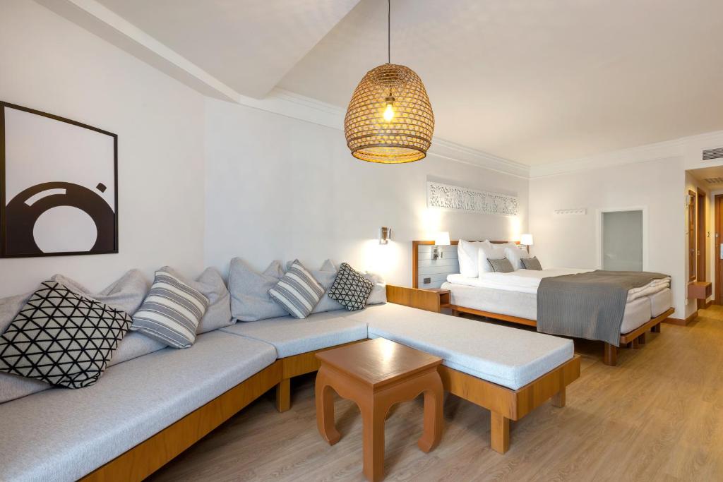 Mūsdienīgs viesnīcas numurs ar plašu stūra dīvānu, ērtām gultām un stilīgu apgaismojumu. Interjera dizainā ir izmantoti gaiši toņi un mūsdienīgas dekorācijas, radot relaksējošu atmosfēru.