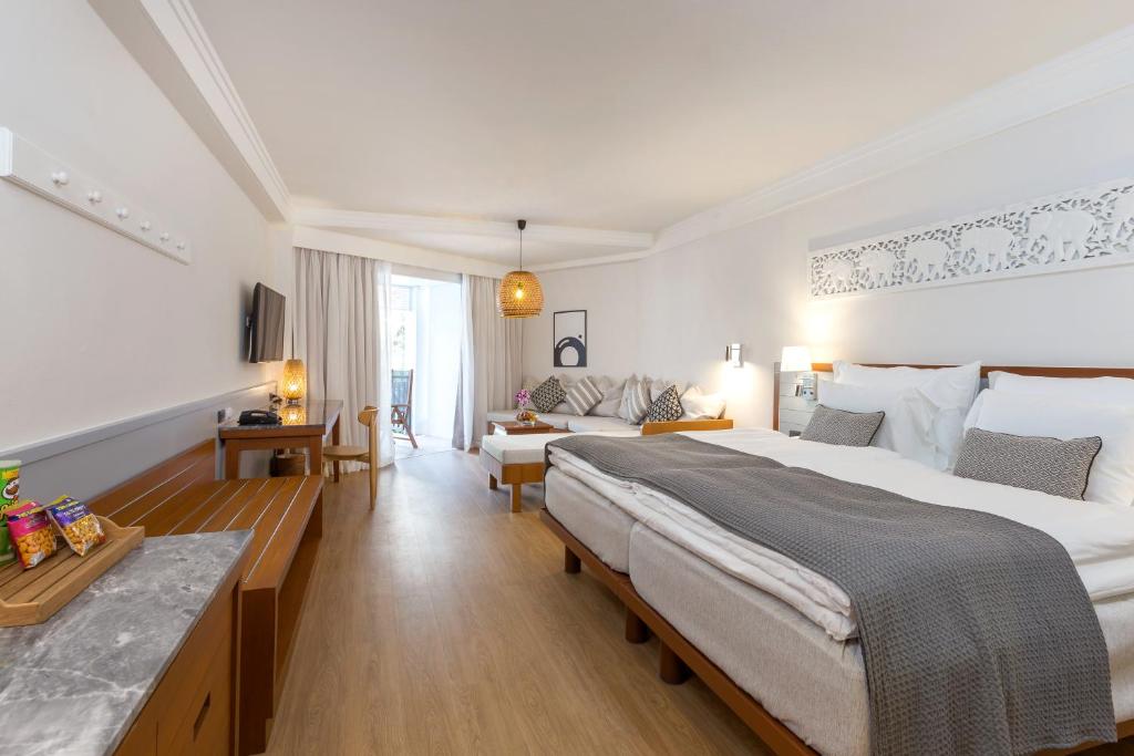 Mūsdienīga viesnīcas numura iekārtojums ar divām gultām, viesistabu, televizoru un balkonu. Interjers ir gaišs un gaumīgs, ar dabīgām krāsām un stilīgām detaļām.