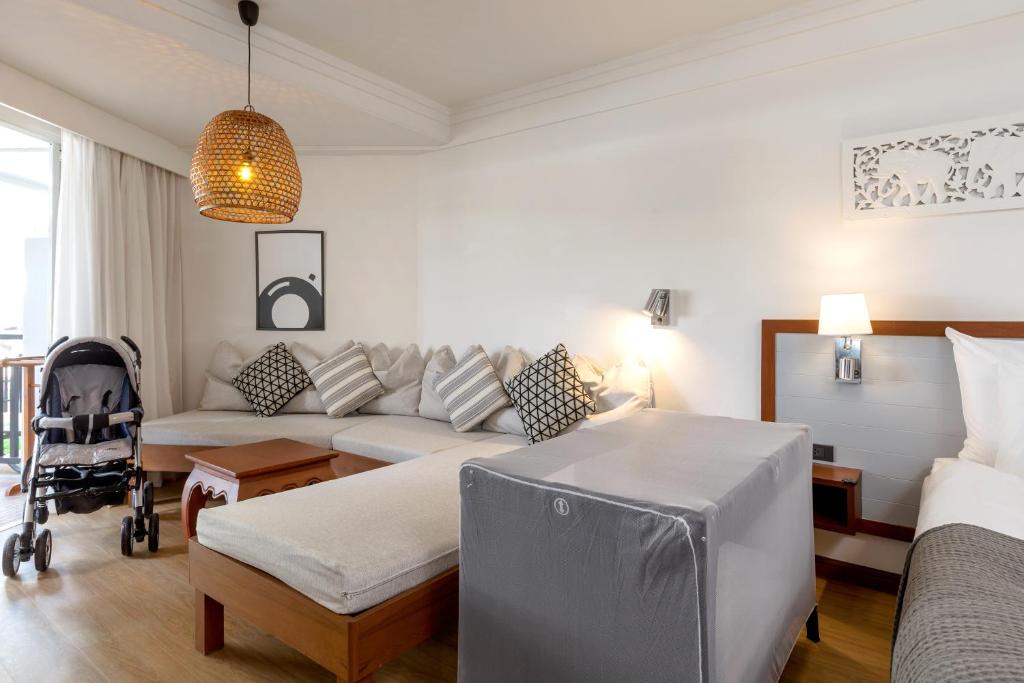 Mūsdienīgs viesnīcas numurs ar ērtu dīvānu, bērnu ratiņiem un gultu, kas nodrošina komfortablu atpūtu ģimenēm. Interjers ir gaišs un mājīgs, radot patīkamu atmosfēru.