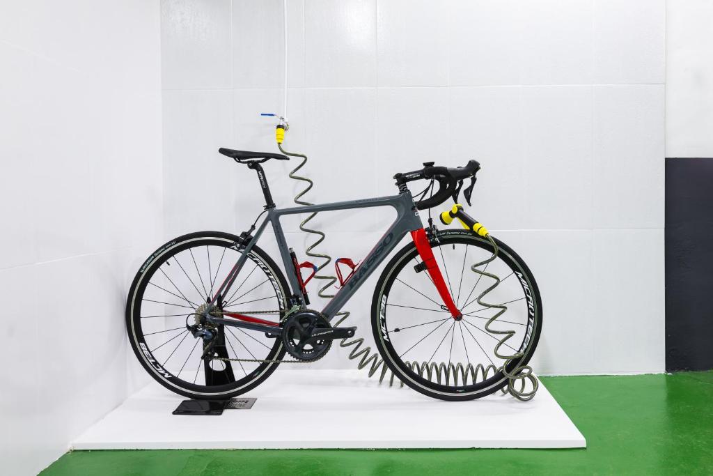 Velosipēds ar modernu dizainu un elastīgu šļūteni, novietots uz balta fona. Ideāls piemērs inovatīvai velosipēdu tehnoloģijai.