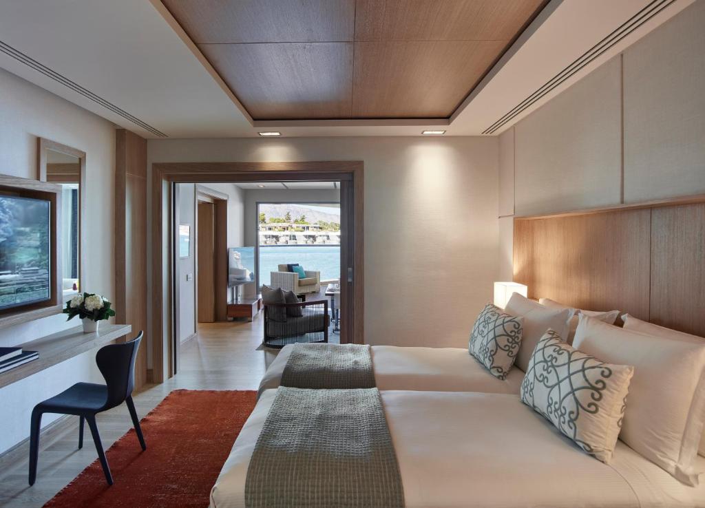 Mūsdienīgs viesnīcas numurs ar divām gultām, elegantu interjeru un skatu uz ūdeni. Telpā ir iekārtots darba galds un sēdvietas atpūtai.