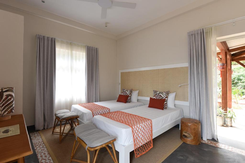 Kaz'alala Hosted B&B numurs ar divām gultām un dabu aiz loga.