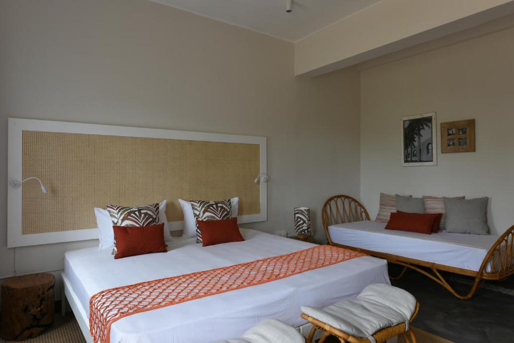 Mūsdienīgs numurs Kaz'alala Hosted B&B ar divām gultām un ratanas mēbelēm.