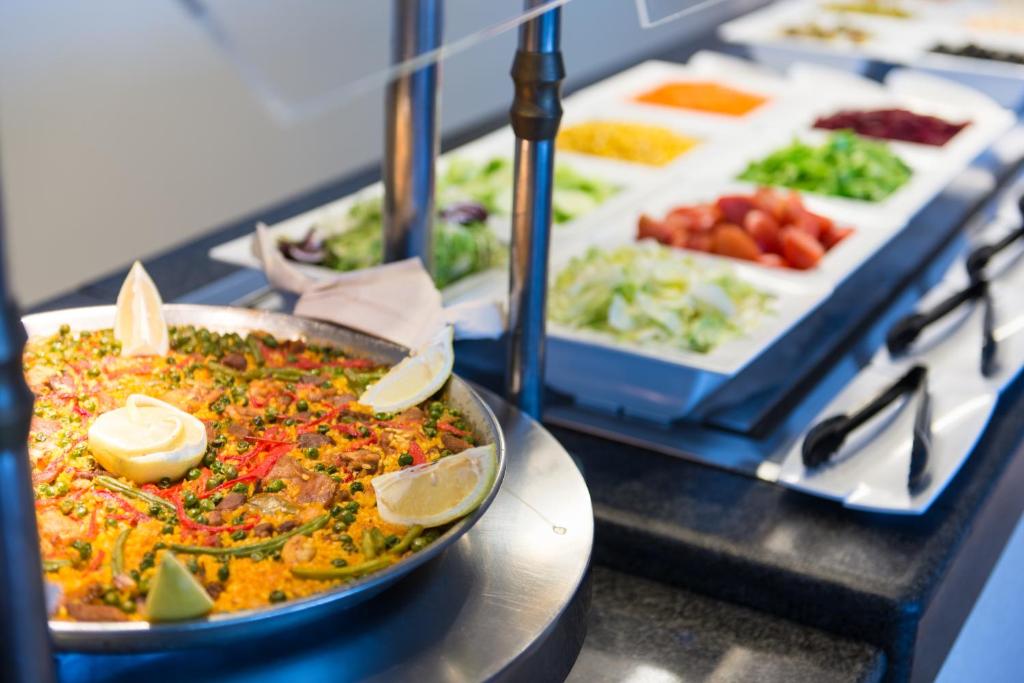 Svaigi pagatavota paelja ar garnījumiem un dārzeņiem, kas izlikta uz bufetes galda.