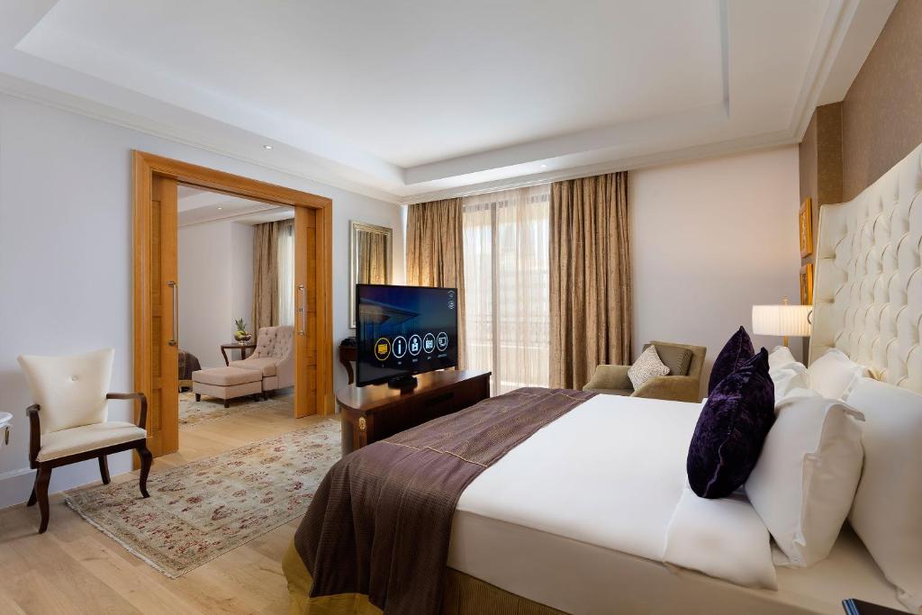 Moderns numurs Titanic Mardan Palace ar ērtu gultu un televizoru.