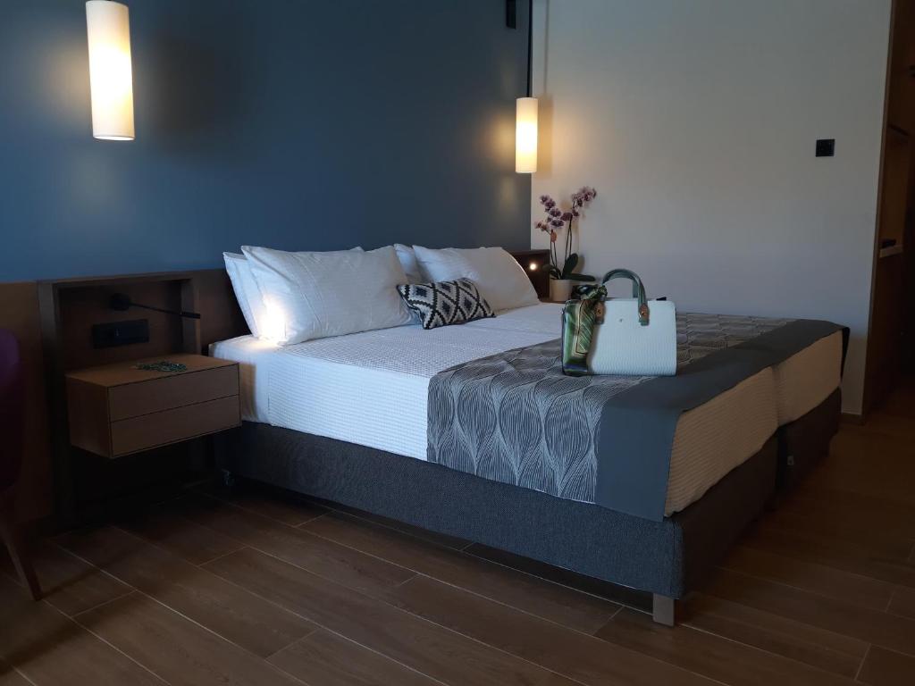 Mūsdienīga guļamistaba ar divguļamo gultu, elegantām gultasveļām un dekoratīvu spilvenu. Uz naktsgaldiņa atrodas lampas un dekoratīvas detaļas, radot relaksējošu atmosfēru.