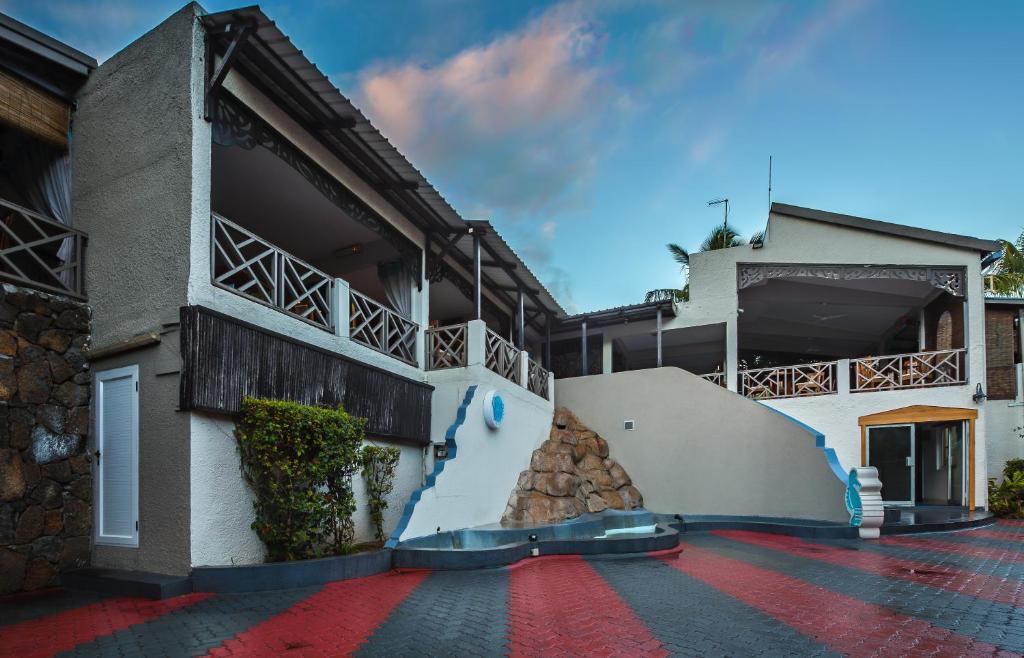 Mūsdienīga viesnīca ar stilīgu arhitektūru un plašiem balkoniem, kas atrodas siltā klimatā. Apkārtne ir rūpīgi iekārtota ar akmens elementiem un zaļām stādījumiem, radot relaksējošu atmosfēru.