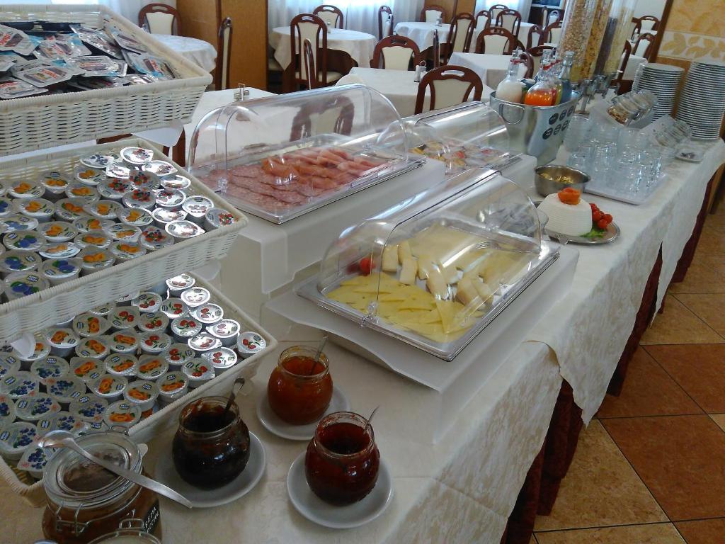 Bufete ar dažādiem ēdieniem, tostarp siera, gaļas un augļu izvēli, kā arī ievārījumiem un dzērieniem. Galdiņi ir sakārtoti viesnīcas restorānā.