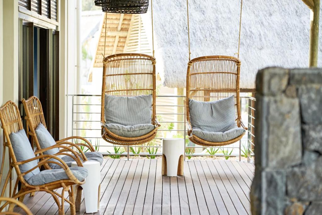 Mūsdienīgs terases dizains ar diviem šūpuļkrēsliem, kas izgatavoti no ratanas, un mīkstiem spilveniem, kā arī koka krēsliem un galdiņu. Ideāla vieta relaksācijai un atpūtai.