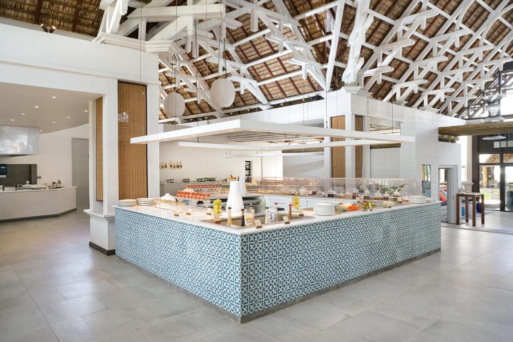 Mūsdienīga restorāna iekārtojums ar plašu, gaišu interjeru un dekoratīvu flīžu bāru. Augsti griesti ar koka konstrukciju piešķir telpai unikālu šarmu.