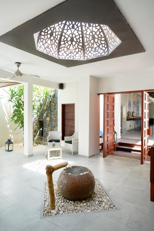 Mūsdienīga viesnīcas iekārtojuma interjers ar dekoratīvu griestu lampu un akmens strūklaku, kas radījusi relaksējošu atmosfēru. Gaismas plūsma un zaļumi pievieno telpai dzīvīgumu.