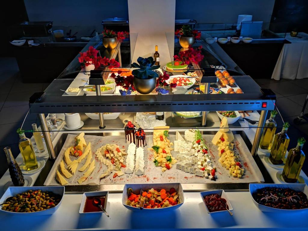 Bagātīgs ēdienu bufete ar dažādām sierām, salātiem un desertiem, rotāta ar ziediem un garšaugiem. Ideāla izvēle svinībām vai svinīgām maltītēm.