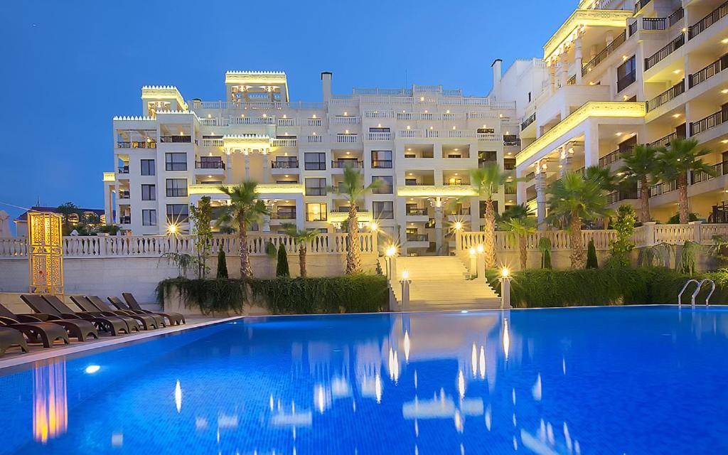 Mūsdienīgs viesnīcas komplekss ar lielu peldbaseinu un apzaļumotu teritoriju pie saulrieta. Eleganta arhitektūra un atpūtas zonas radīt relaksējošu atmosfēru.