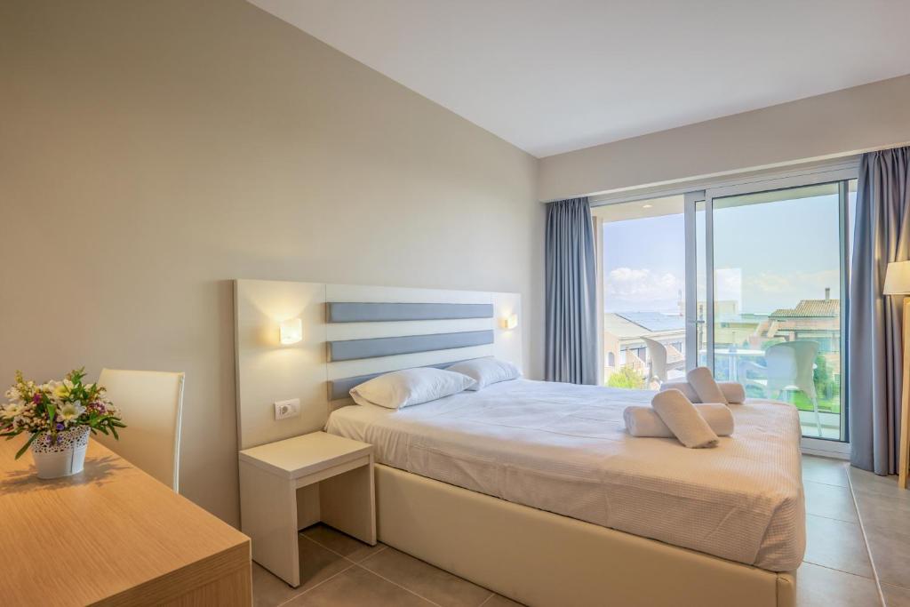 Mūsdienīga guļamistaba ar plašu logu, kas piedāvā skatu uz jūru, un ērti iekārtotu gultu. Interjers ir gaišs un elegants, radot relaksējošu atmosfēru.