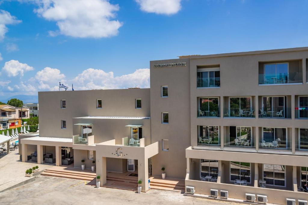 Moderns viesnīcas ēka ar balkoniem un terasi, apzaļumota apkārtne un skaidras debesis. Ideāla vieta relaksācijai un atpūtai.