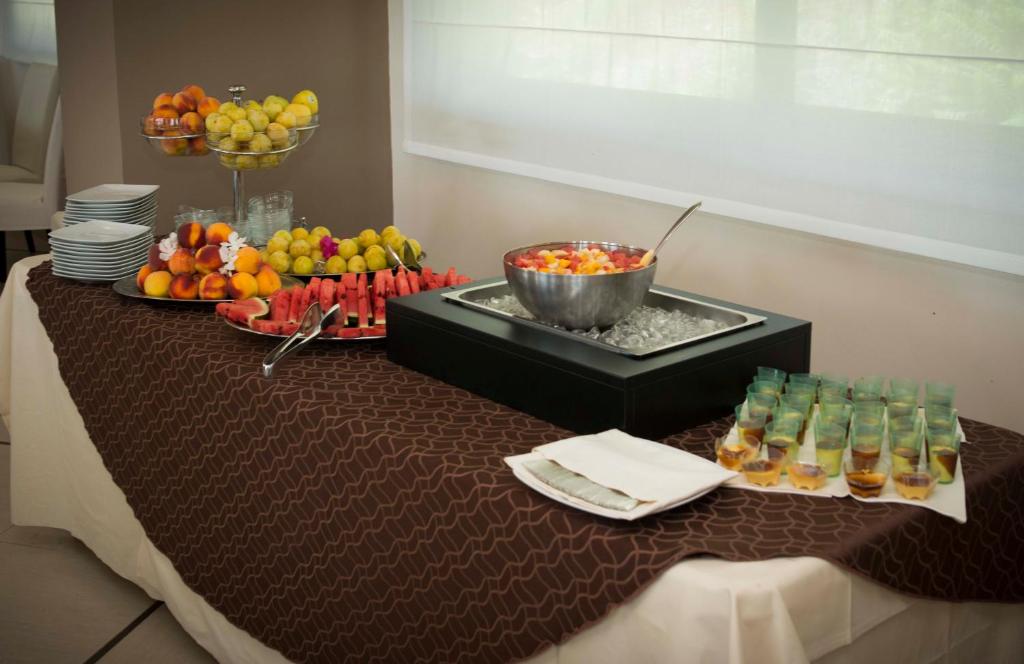 Augļu bufete ar dažādiem svaigiem augļiem un saldām uzkodām, kas pasniegtas uz galda. Iekļauta arī augļu salātu bļoda un mazas porcijas desertiem.